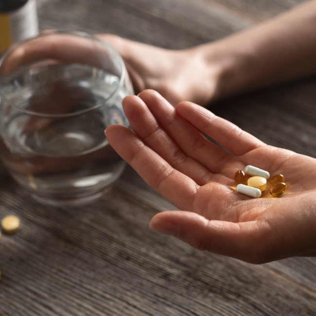 hand holding zinc supplements and glass of water