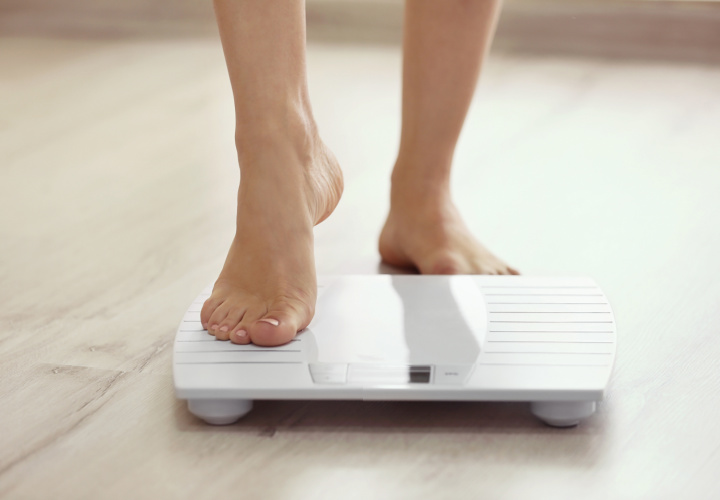 Woman weighing herself.