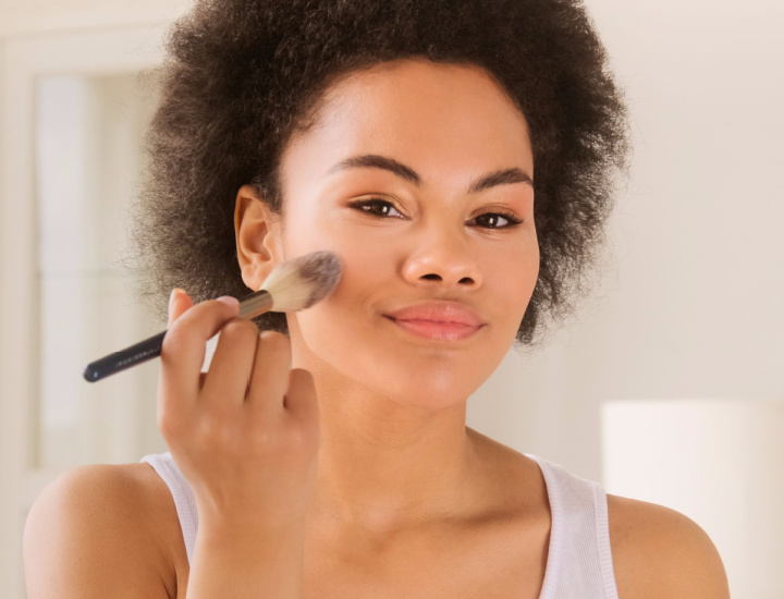 Woman applying makeup with a brush