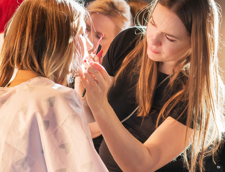 Woman applying makeup to another woman