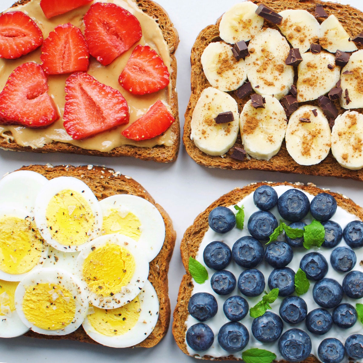 slices of toast topped with eggs, nut butter, and fruit