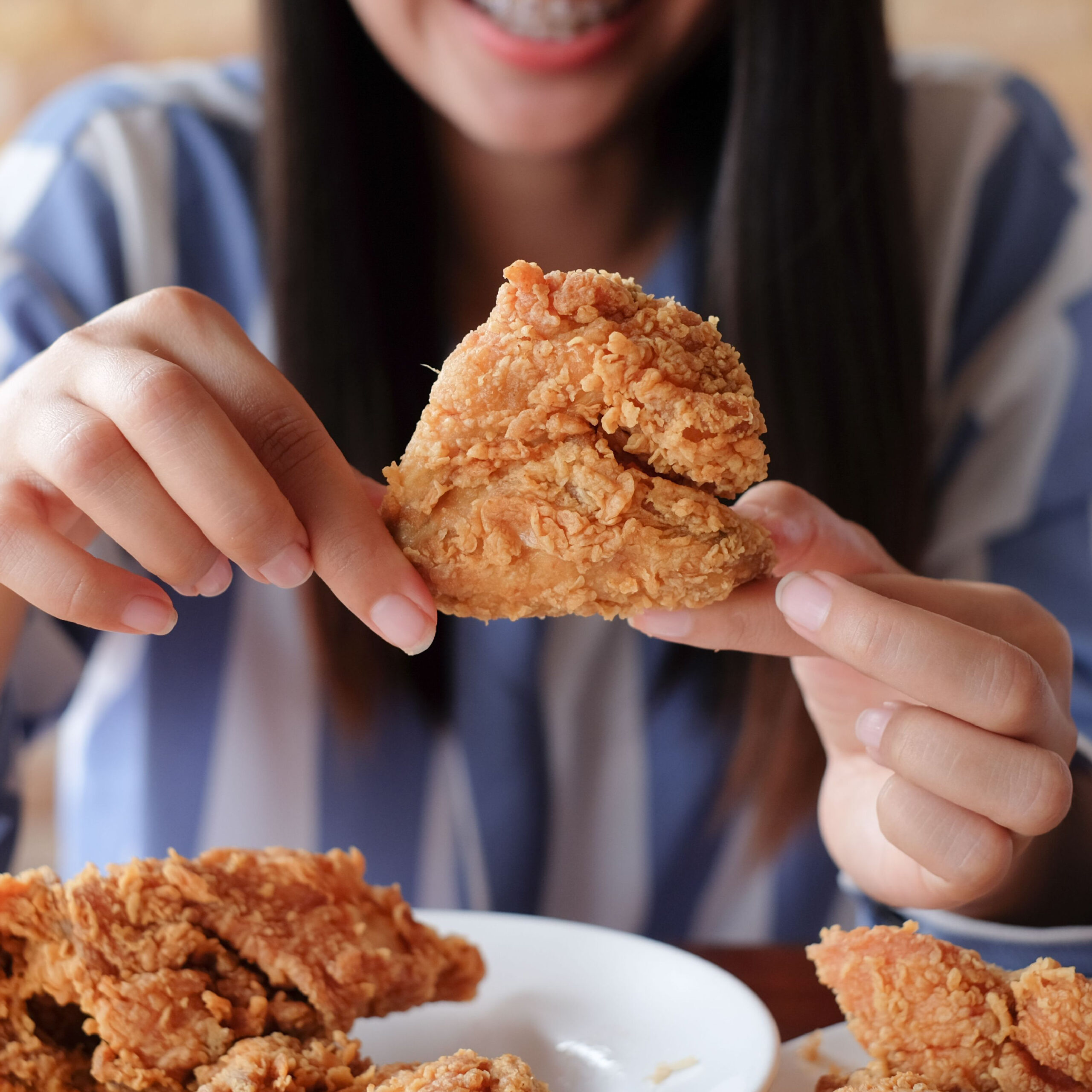 woman holding fried chicken