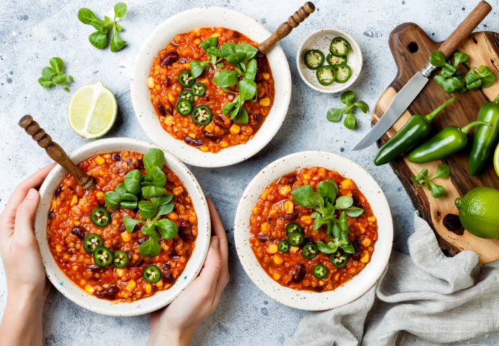 Three bowls of vegetarian chili on a table