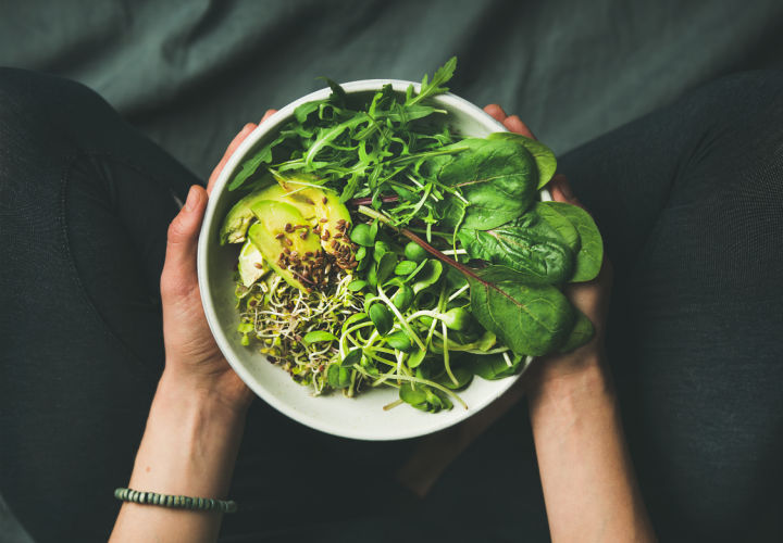 Person holding a bowl of raw food