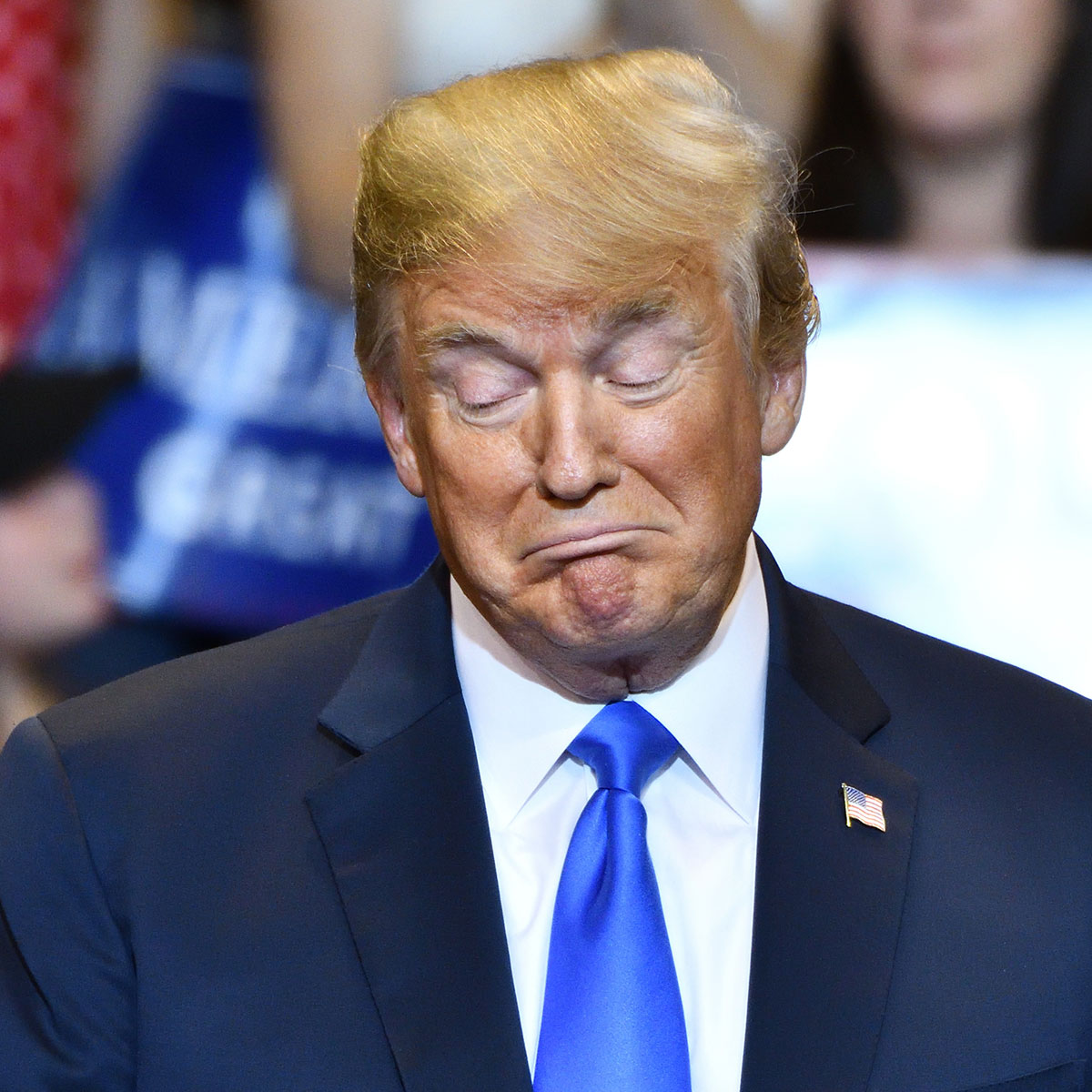 donald trump blue tie orange skin yellow hair blue suit rally frowning