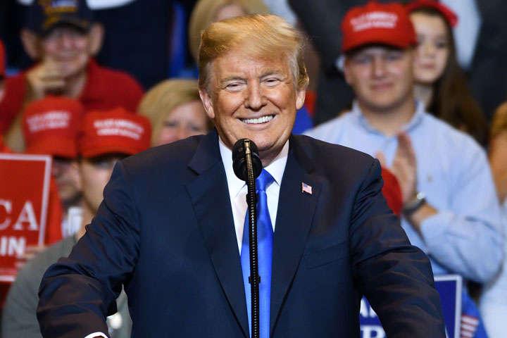 Donald Trump smiling at podium for speech