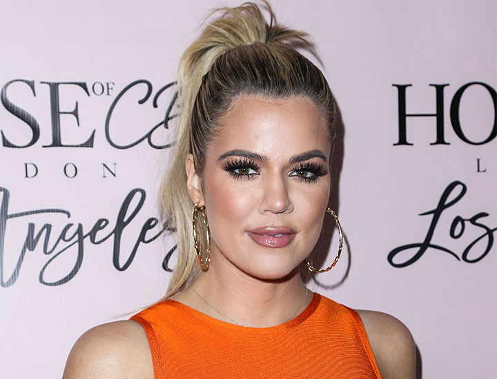 Khloe Kardashian wearing an orange dress