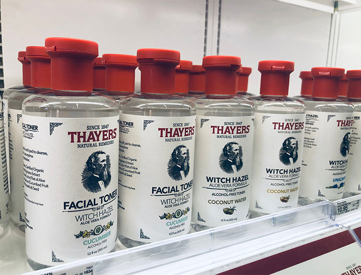 red-and-white bottles of thayer's witch hazel skincare products on white store shelf