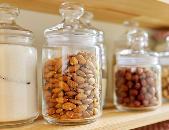 almonds and other nuts in glass jars on shelf