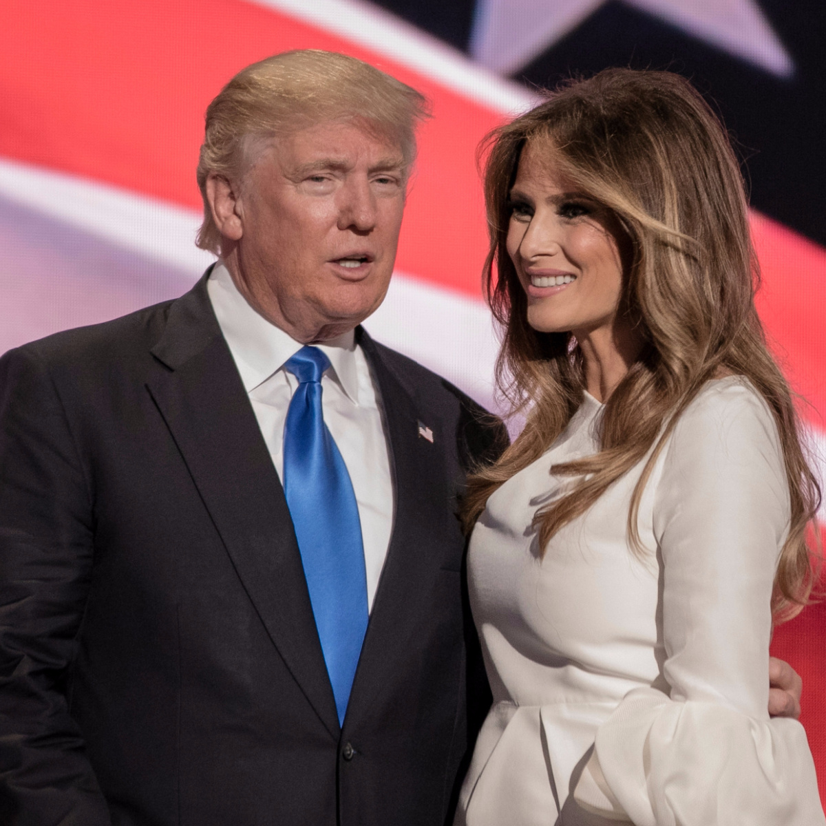 donald trump black suit blue tie convention melania trump tan beige dress arm around her