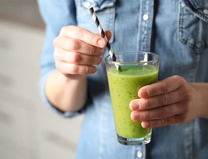 Person drinking a green smoothie