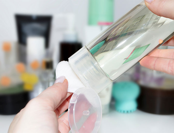 Face toner squeezed onto cotton pad