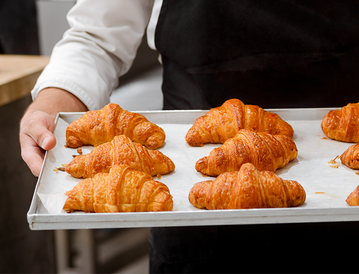 Chef carrying fresh baked croissants