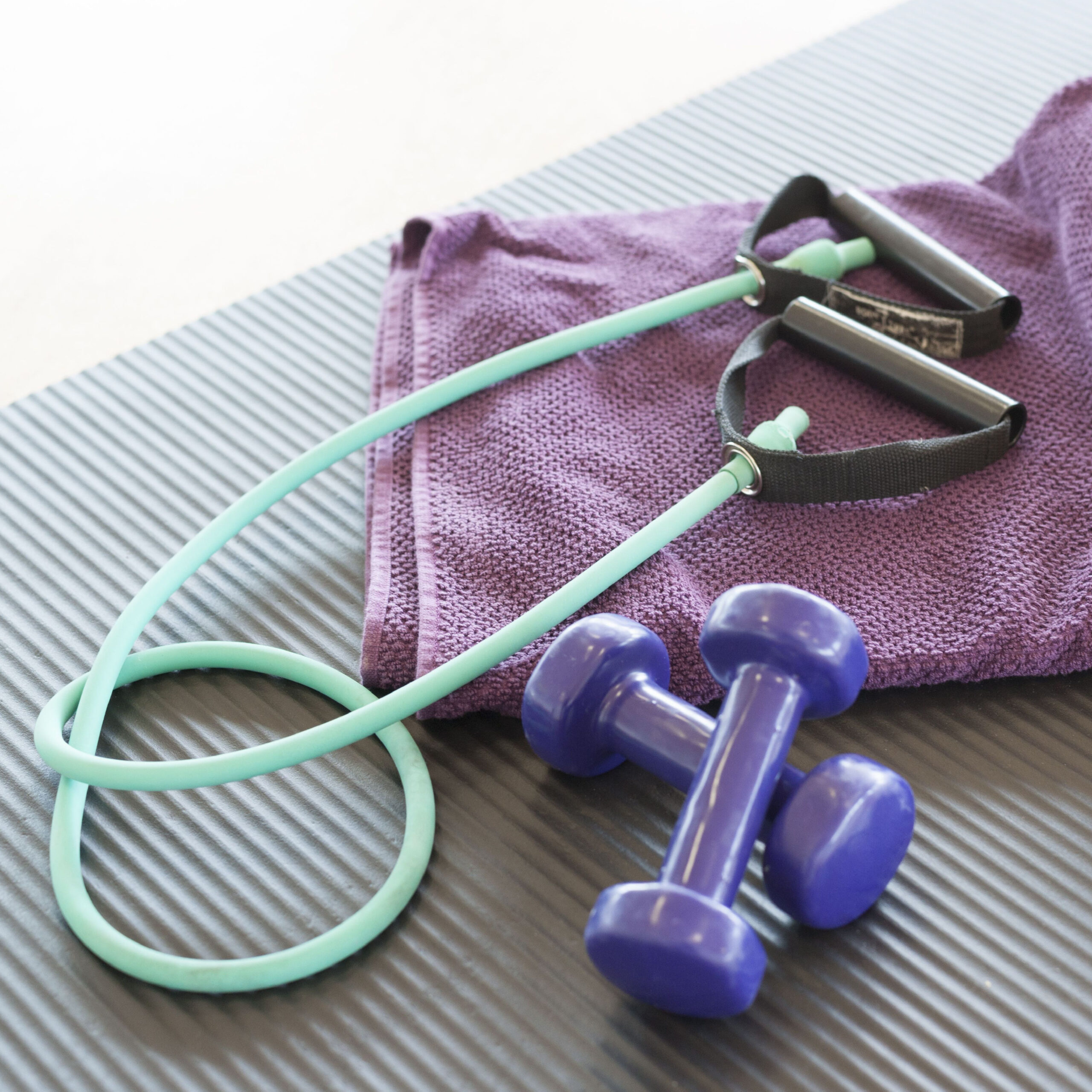 jump rope and purple weights with purple towel at gym