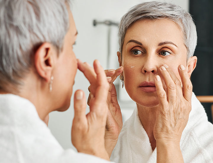 older-woman-applying-skincare