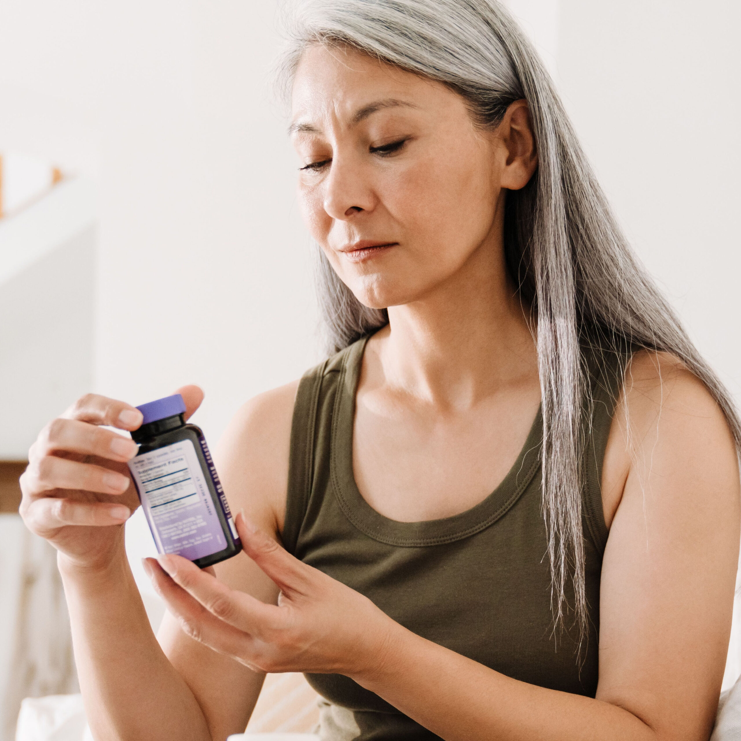 woman reading supplement bottle