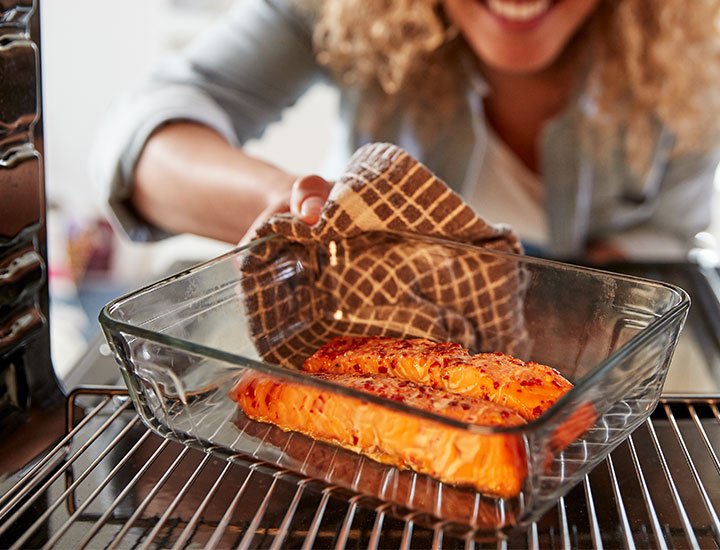 Woman baking salmon filet