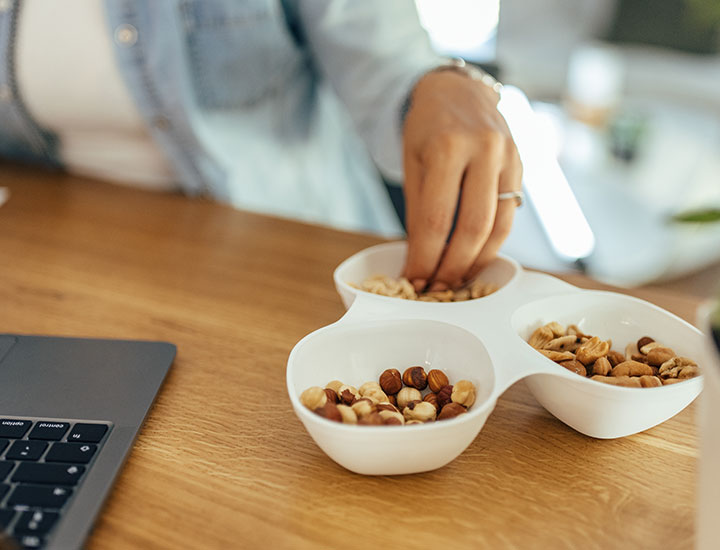 Woman eating a bowl of nuts