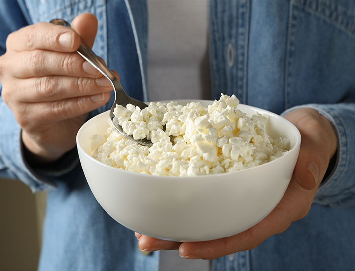 Woman eating from a bowl of cottage cheese