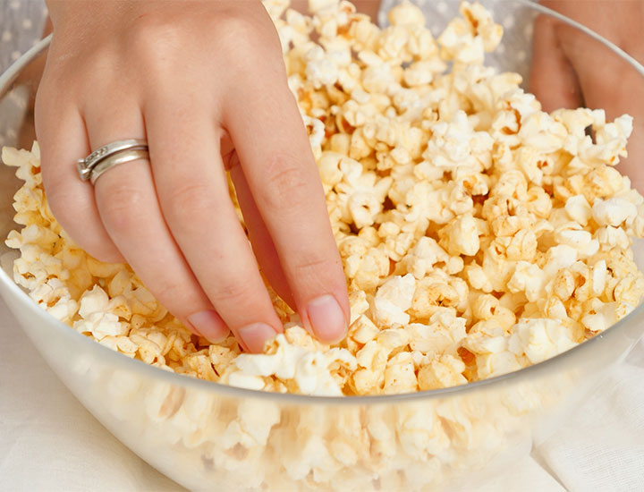 Woman eating popcorn in a bowl