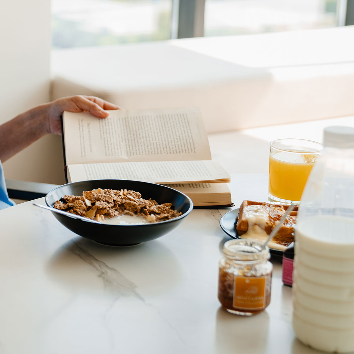 https://www.shefinds.com/files/2023/04/woman-eats-breakfast-reading-a-book.jpg