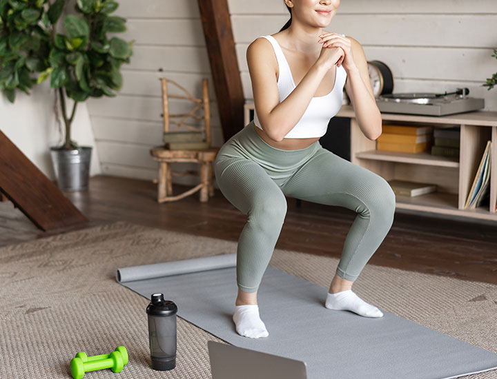 Woman exercising at home on yoga mat