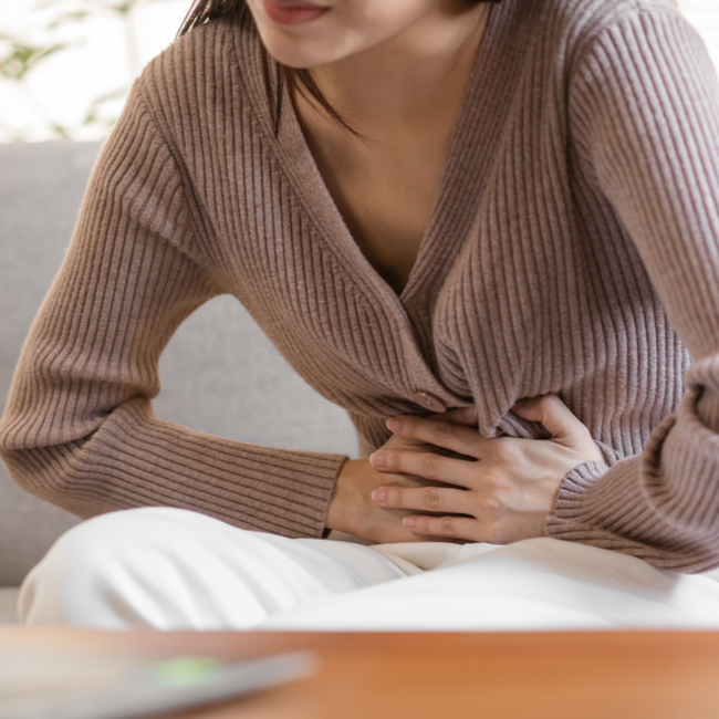 woman holding stomach with digestive pain