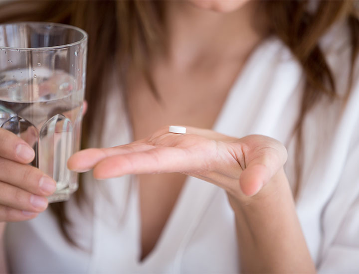 Woman taking vitamins with water