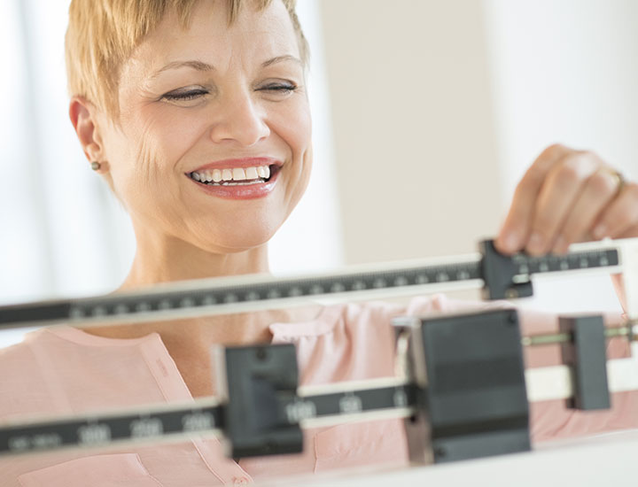 Woman weighing herself on a scale