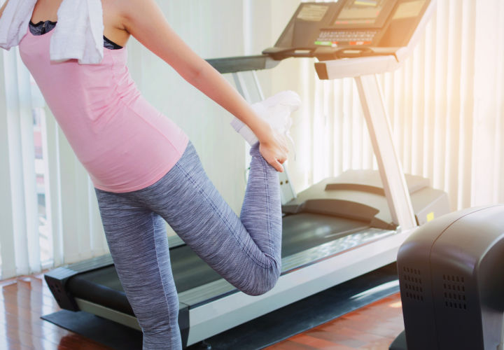 Woman stretching after being on a treadmill