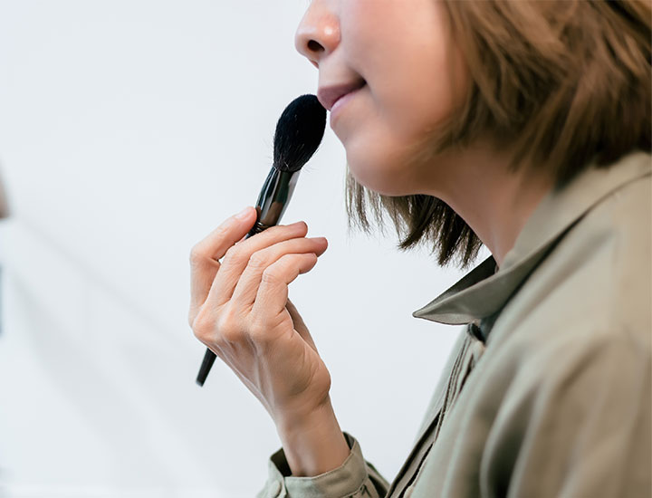 woman-using-brush-apply-makeup