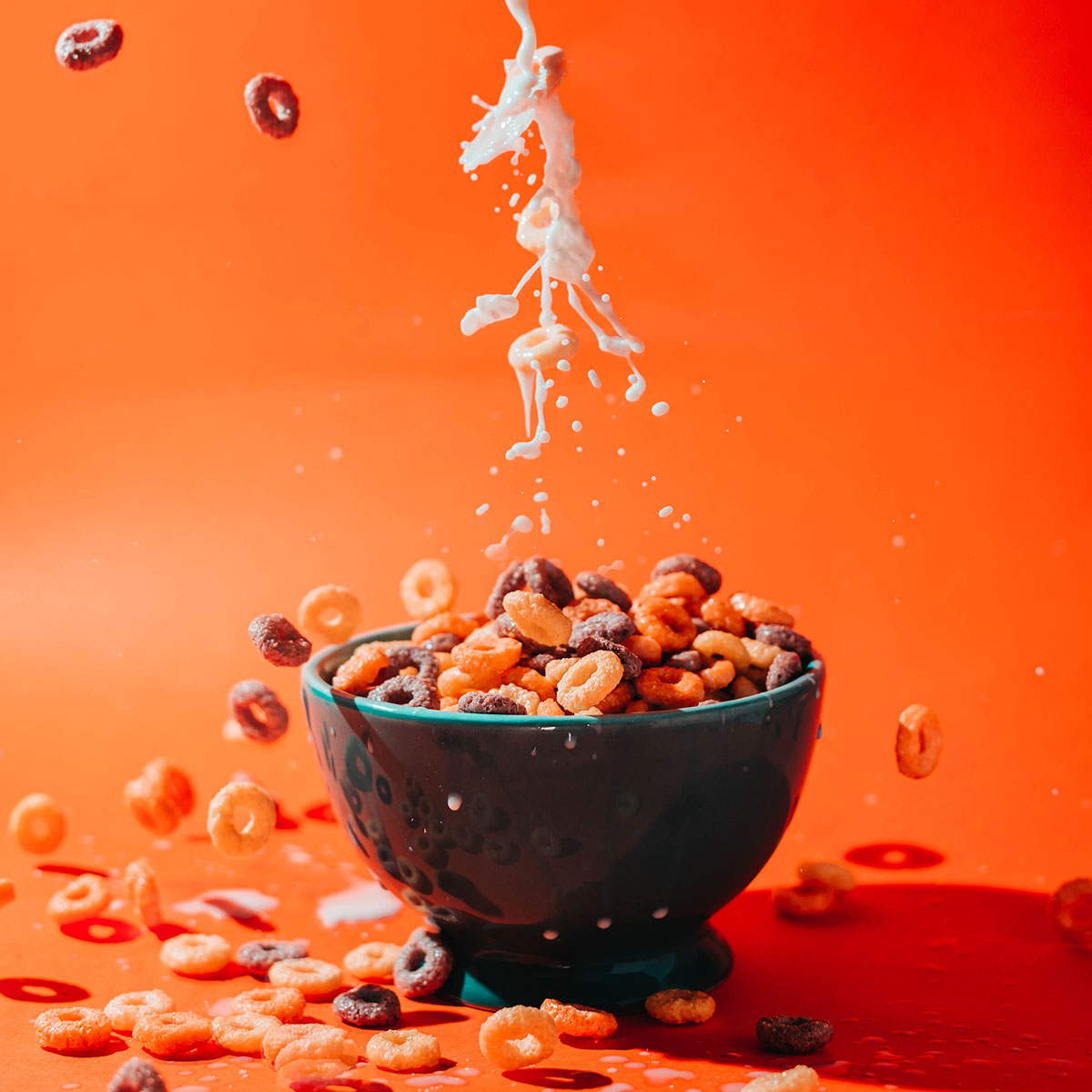 milk pouring into overflowing bowl of cereal