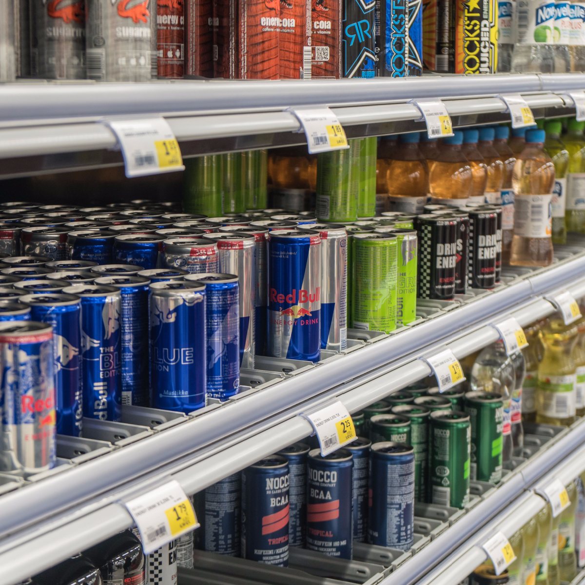 energy drink cans lined up on store shelves multicolored