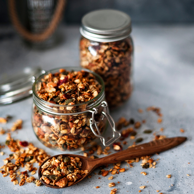 granola in small glass jar beside spoon