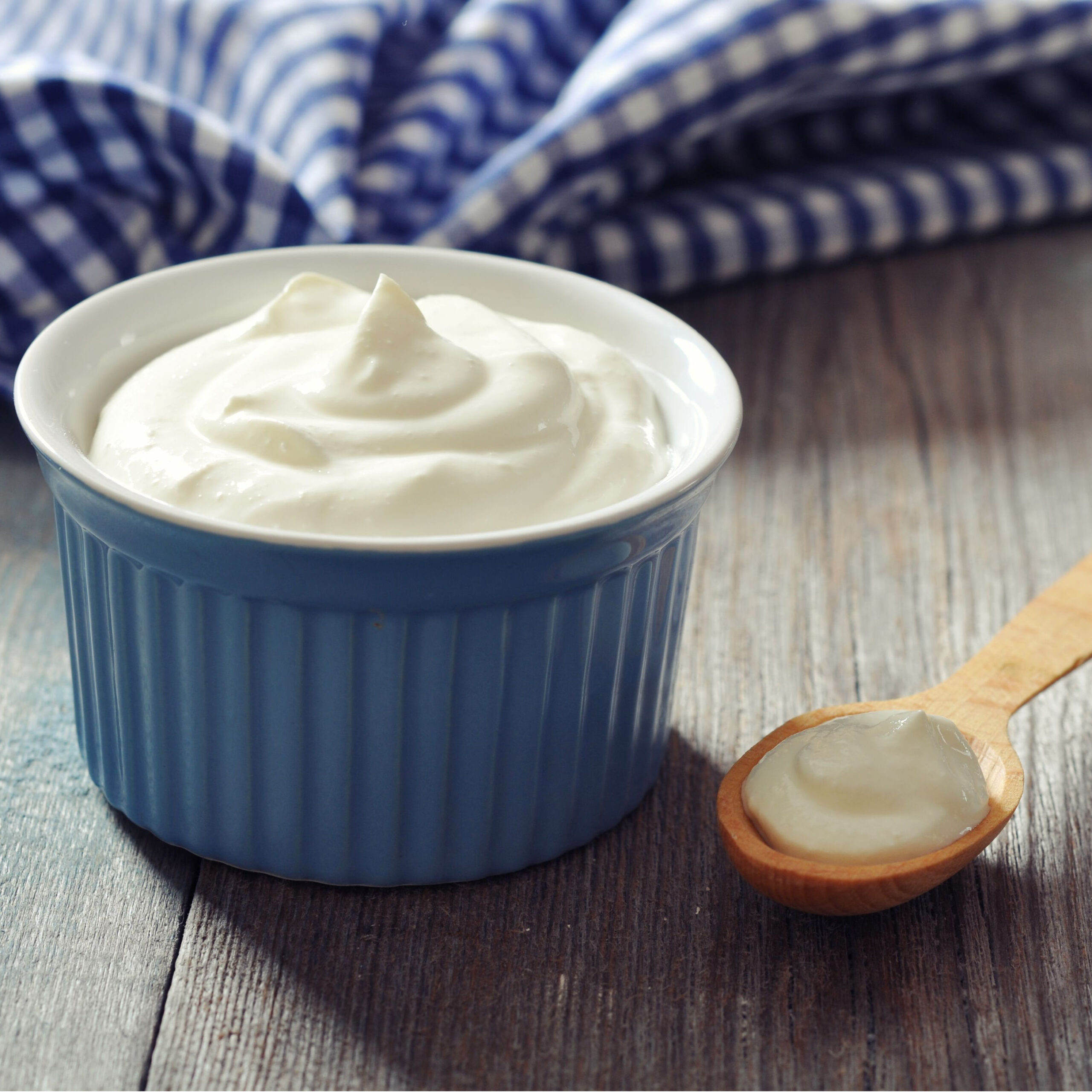 bowl of greek yogurt with spoonful beside it