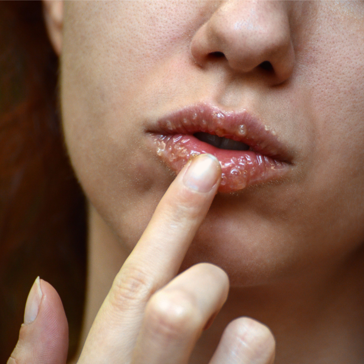 woman using homemade lip scrub and applying to mouth with finger