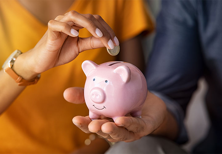 Woman putting money in piggy bank