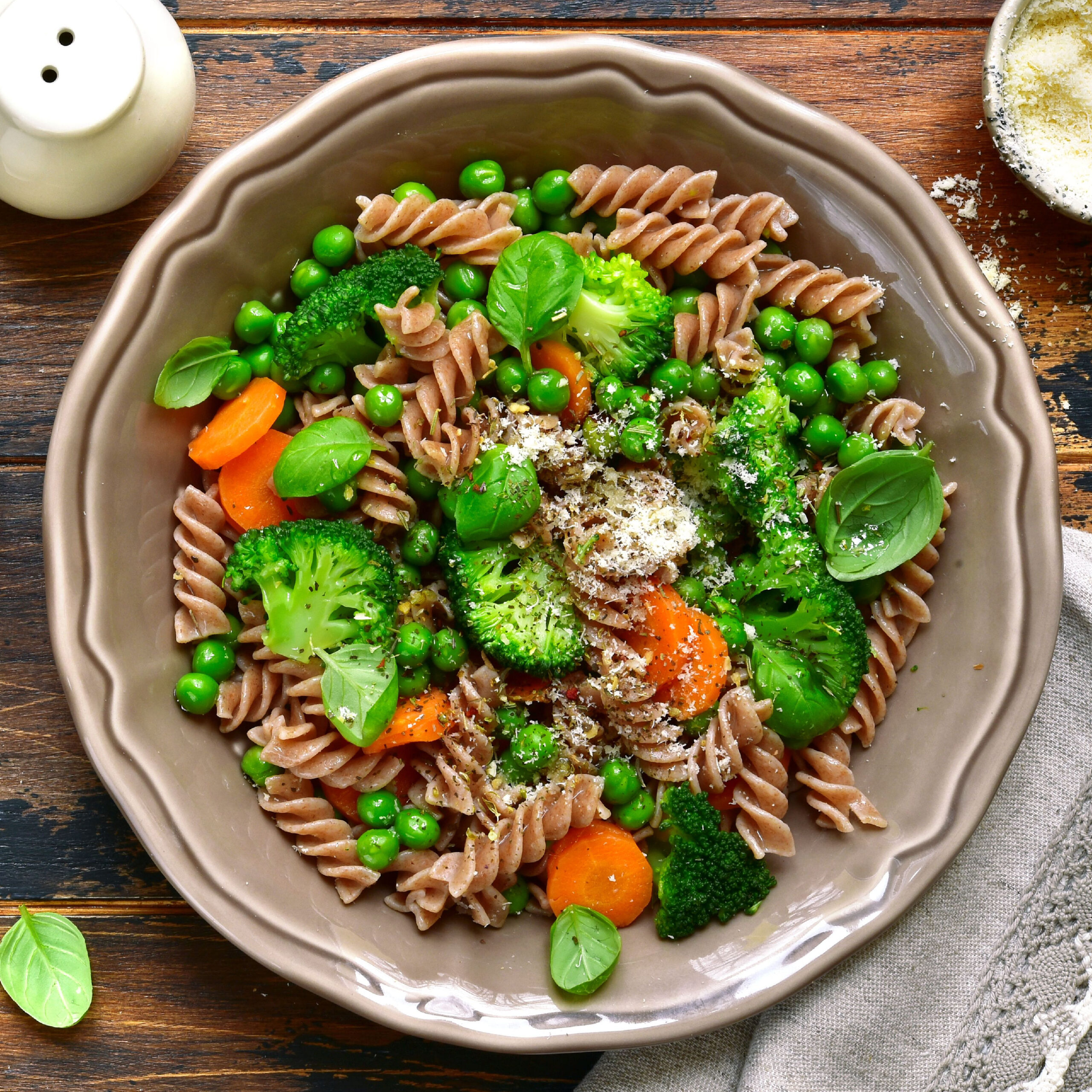 plate of whole wheat pasta with carrots, broccoli, and peas