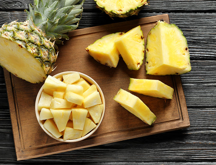 Sliced and diced pineapple on a cutting board