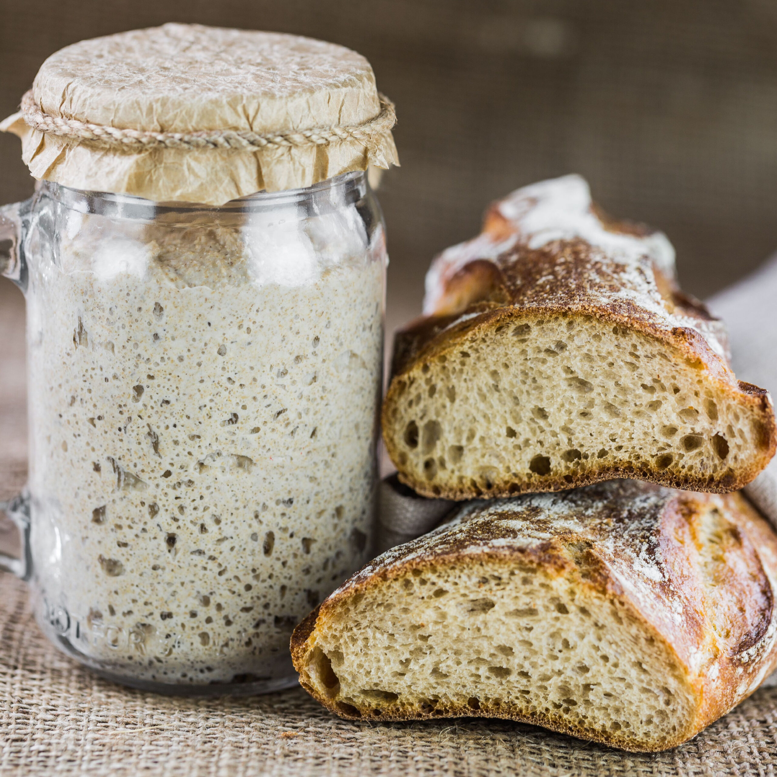 sourdough bread beside jar of sourdough starter