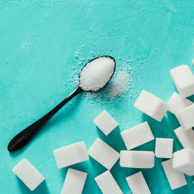 sugar cubes next to spoonful of sugar