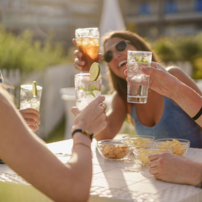 group of young people toasting drinks outside