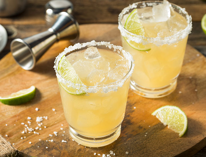 Two salted margaritas on table