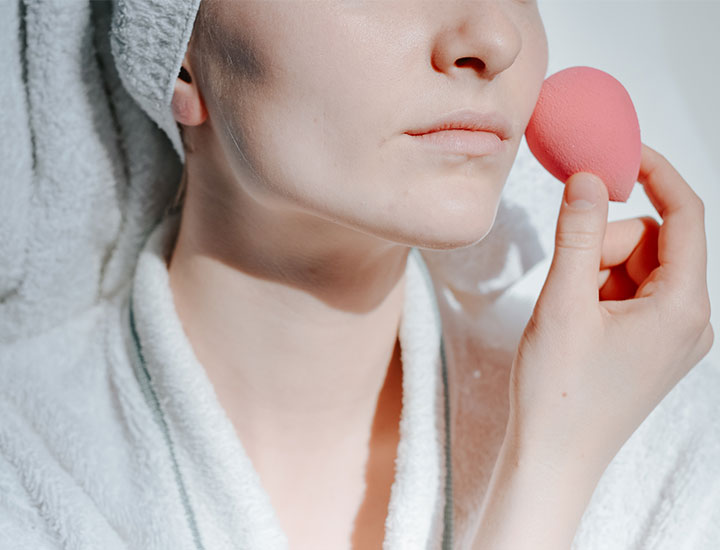 woman-applying-makeup-blender-sponge