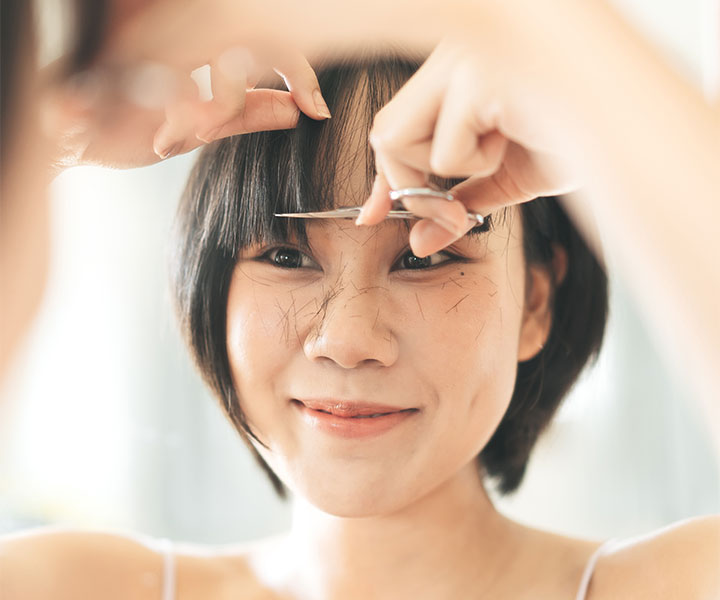 woman-cutting-her-own-bangs