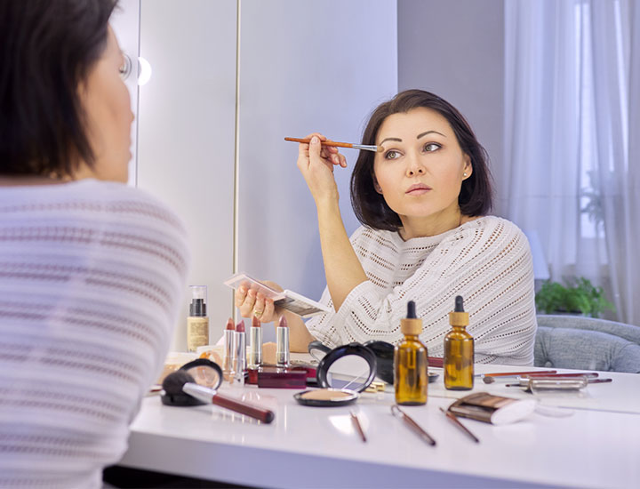 woman-applying-makeup-vanity