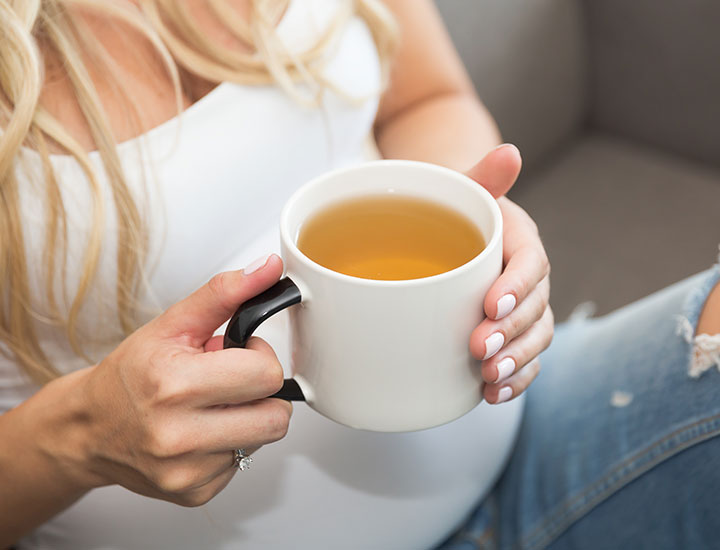 Woman holding a mug of green tea