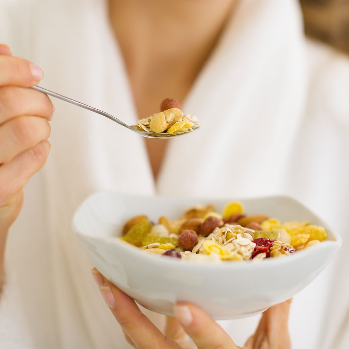 woman eating oatmeal with dried fruit