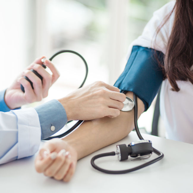 woman having blood pressure checked at doctor