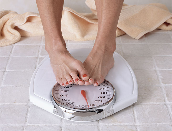 Woman nervously standing on a scale